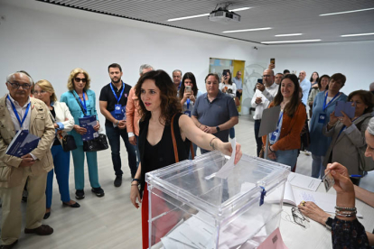 La presidenta de la Comunidad de Madrid, Isabel Díaz Ayuso (c), ejerce su derecho al voto en un colegio electoral de Madrid.