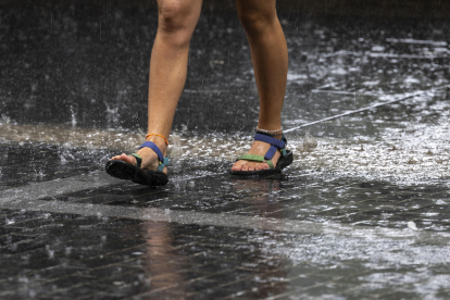 Una turista camina bajo la lluvia este martes en San Sebastián. EFE/Javier Etxezarreta