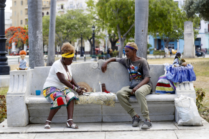 Un hombre se consulta con una mujer que lee las cartas, en el Parque de la Fraternidad en La Habana (Cuba). EFE/ Yander Zamora