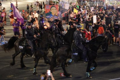 La policía utiliza caballos para dispersar a los manifestantes que bloquean una carretera y piden al gabinete de guerra israelí que firme un acuerdo de rehenes durante una manifestación frente al cuartel general militar de Kirya en Tel Aviv, Israel, el 15 de junio de 2024. EFE/EPA/ABIR SULTAN