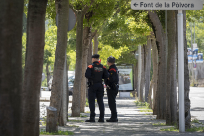 Agentes de los Mossos  delante del barrio de Font de la Pòlvora de Girona, donde la pasada noche un hombre y una mujer fallecieron y otras dos personas resultaron heridas de gravedad en una pelea que acabó a tiros y con el atropellamiento de al menos una las víctimas. EFE/ David Borrat