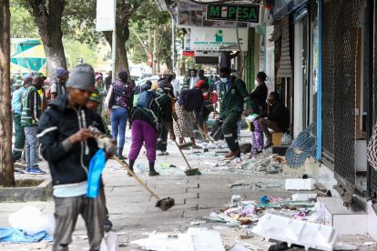 La gente limpia una acera llena de vidrios rotos en Nairobi, Kenia, tras la huelga nacional contra los aumentos de impuestos que resultó mortal el 25 de junio de 2024. EFE/EPA/DANIEL IRUNGU