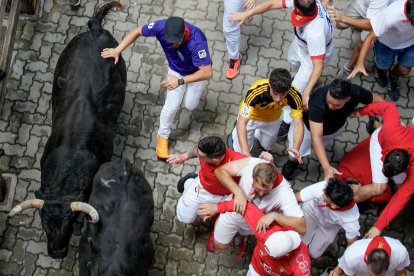 PAMPLONA, 12/07/2024.- Los mozos son perseguidos por toros de la ganadería de Jandilla, de Mérida (Badajoz), durante el sexto encierro de los Sanfermines 2024, este viernes en Pamplona. EFE/Ainhoa Tejerina