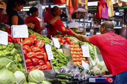 Un hombre compra en un puesto de fruta y verduras de un mercado de Madrid, en una fotografía de archivo. EFE/ Luis Millan