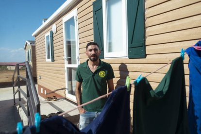 Gregorio posa ante uno de los domicilios prefabricados en los que viven algunos de los migrantes.