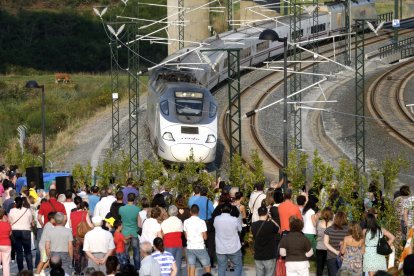 Familiares de víctimas observan el paso del tren de las 20:40 en la curva de Angrois, justo un año después del accidente, durante el acto del aniversario de la tragedia ferroviaria en la que murieron 79 personas, esta tarde en Angrois, en Santiago de Compostela.