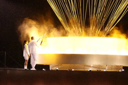 Los atletas galos Marie-Jose Perec (i) y Teddy Riner (d) encienden el pebetero durante la ceremonia de inauguración de los Juegos.