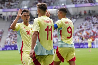 El futbolista español Fermín López (c) celebra con sus compañeros Abel Ruiz (d) y Aimar Oroz (i) tras marcarle un gol a la República Dominicana durante el partido del Grupo C de fútbol masculino de los Juegos Olímpicos de París 2024 disputado en el Estadio de Burdeos. EFE/ M. Reino