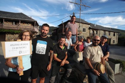 Vecinos de San Cristóbal de Valdueza en la plaza del pueblo para pedir a la Diputación que les arregle 8 kilómetros de carretera destrozada desde Salas de los Barrios.