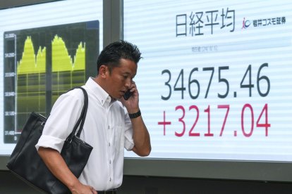 Tokyo (Japan), 06/08/2024.- A pedestrian walks past a display showing the closing information of the Nikkei Stock Average in Tokyo, Japan, 06 August 2024. Tokyo's stock benchmark recorded its largest single-day gain in history, gaining over 3,200 points, after losing over 4,400 points on 05 August 2024, bigger than the 'Black Monday' historic loss in 1987. The Nikkei Stock Average surged 3,217.04 points, or 10.23 per cent, to close at 34,675.46 on 06 August 2024. (Japón, Tokio) EFE/EPA/KIMIMASA MAYAMA