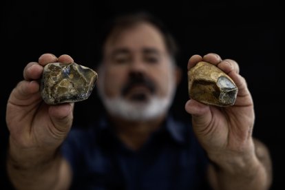 El fotógrafo Juan María Álvarez muestra unos núcleos tallados del Paleolítico. Piedras talladas del Paleolítico, como puntas musterienses, raederas o denticulados, además de moluscos y restos óseos de animales del período Holoceno, son algunos de los cientos de vestigios prehistóricos que un vecino de Málaga ha hallado casualmente en unos montículos de arena depositada en la playa Sacaba. EFE/Jorge Zapata.