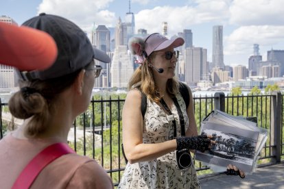 La escritora y una de las fundadoras del tour de gatos en Brooklyn, Peggy Gavan (c), muestra una imagen a un grupo de mujeres este lunes en Nueva York (EE.UU.). EFE/ Ángel Colmenares