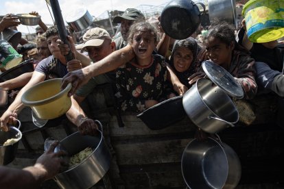 Palestinos desplazados internos reciben alimentos donados por una organización benéfica, en el campamento de Jan Yunis, en el sur de la Franja de Gaza, el 6 de septiembre de 2024. EFE/EPA/HAITHAM IMAD