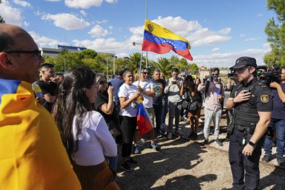 Simpatizantes del excandidato opositor a la Presidencia de Venezuela, Edmundo González Urrutia, conversan con un miembro de la Policía Nacional en la puerta de la base aérea de Torrejón de Ardoz (Madrid)