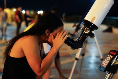 Una mujer observa por un telescopio el eclipse lunar en Asunción (Paraguay).