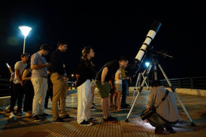 Un hombre observa por un telescopio el eclipse lunar en Asunción.