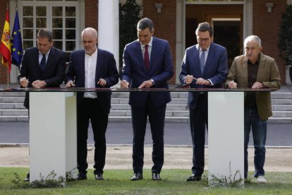 El presidente del Gobierno, Pedro Sánchez, firma junto a los representantes de la patronal y los sindicatos el nuevo acuerdo en materia de pensiones este miércoles en el Palacio de la Moncloa.