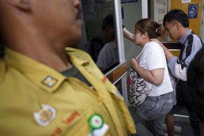 Familiares de los fallecidos por el incendio en un autobús escolar en Bangkok llegan al Instituto Forense para identificar a las víctimas. 
                      EFE/EPA/NARONG SANGNAK