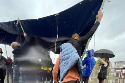 La lona sostenida por los padres para tapar a los estudiantes.