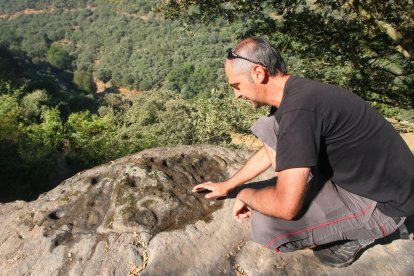 Juan Carlos Garrido, vecino de Santa Marina del Sil, junto a algunos de los petroglifos aparecidos en varias zonas cercanas a la localidad.