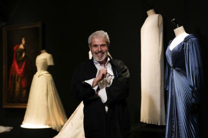 El modisto Lorenzo Caprile posa ante algunas de las piezas de la exposición 'Caprile Lorenzo', un viaje por los vestidos más icónicos del modista durante la inauguración de la muestra este martes en la Sala Canal de Isabel II en Madrid. EFE/ Borja Sanchez-Trillo