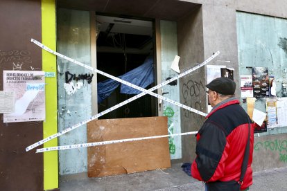 Un peatón se detiene ante el local donde dos personas que dormían en su interior han fallecido esta madrugada a causa de un incendio, según los datos iniciales facilitados a EFE por fuentes cercanas a la investigación. EFE/ Raquel Manzanares