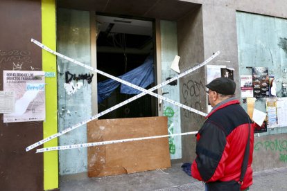 Un peatón se detiene enfrente del cajero donde dos personas que dormían en su interior han fallecido esta madrugada a causa de un incendio