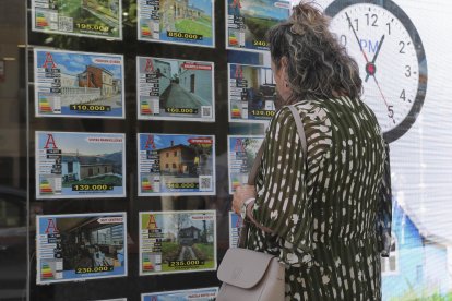 Imagen de archivo de una mujer delante del escaparate de una agencia inmobiliaria. EFE/J.L.Cereijido