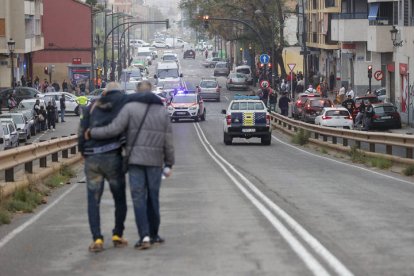 Dos personas abandonan el barrio de La Torre de Valencia, uno de los barrios periféricos de la zona sur que sufre inundaciones a causa de las fuertes lluvias de las últimas horas.