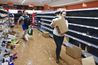 Varios residentes recogen alimentos en un supermercado en la localidad de Paiporta, Valencia, este jueves.