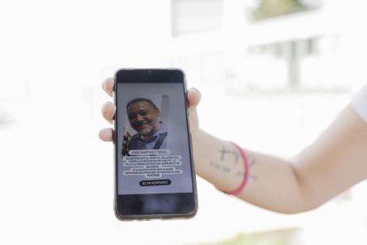 Una vecina de Alaquàs muestra a los medios una fotografía de su hermano desaparecido, José Martínez Toral, a las puertas de la morgue improvisada que ha sido instalada en la Feria de Valencia, este viernes.