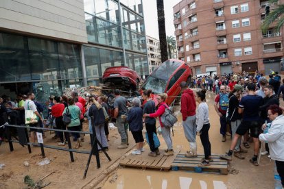 Varias personas esperan para recibir ayuda este jueves en Paiporta (Valencia).