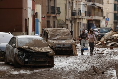 Vecinos de Paiporta trabajan en la limpieza de calles, locales y viviendas de la localidad junto a una montaña de vehículos arrastrados por la corriente, este viernes. Las víctimas mortales en la provincia de Valencia a causa de la devastadora dana ha aumentado este viernes hasta las 205, según el último recuento facilitado por el Centro de Emergencias de la Generalitat Valenciana. EFE/Biel Aliño