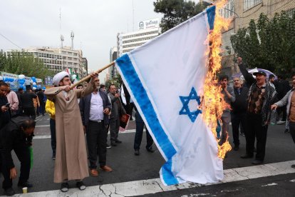 Un clérigo iraní quema una bandera israelí durante una concentración contra Estados Unidos con motivo del 45 aniversario de la toma de la embajada estadounidense, frente al antiguo edificio de la legación diplomática en Teherán, el 3 de noviembre de 2024. EFE/EPA/ABEDIN TAHERKENAREH