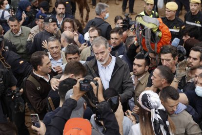 El rey Felipe habla con vecinos durante su visita este domingo a Valencia. Gritos de 'fuera', así como lanzamiento de barro, están recibiendo a la comitiva de los reyes de España, el presidente del Gobierno, Pedro Sánchez, y el president de la Generalitat, Carlos Mazón, a su llegada al centro de Paiporta.