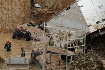 Expertos de la Guardia Civil buscan cuerpos sin vida entre los vehículos entre los cimientos de un edificio en construcción, este sábado, en Paiporta, Valencia. EFE/ Biel Aliño