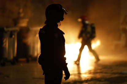 Un agente de la policía Nacional en la plaza de Virgen, en Valencia, tras la manifestación en la que cerca de 40 organizaciones sociales, cívicas y sindicatos de izquierda de la Comunitat Valenciana han marchado este sábado en protesta por la gestión de la dana y con el lema "Mazón dimisión", en alusión al president de la Generalitat. EFE/Jorge Zapata