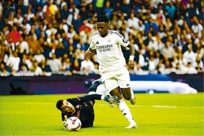 Vinicius, autor de tres goles, regatea al portero rival.