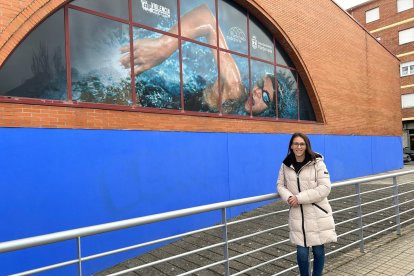 La concejala de Deportes, Eva González, bajo el nuevo vinilo de las piscinas.