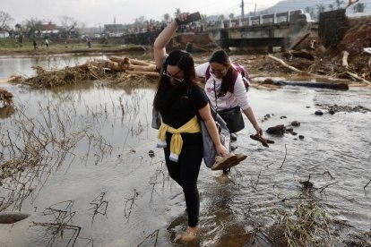 Santa Ana (Philippines), 15/11/2024.- Filipino villagers cross a river next to a damaged bridge affected by Typhoon Usagi, in the coastal municipality of Santa Ana, Cagayan province, Philippines, 15 November 2024. Typhoon Usagi, the fifth major typhoon to hit the Philippines, brought more damaged after the onslaught of Typhoons Toraji, Trami, Yinxing and Kong-rey. (Filipinas) EFE/EPA/FRANCIS R. MALASIG