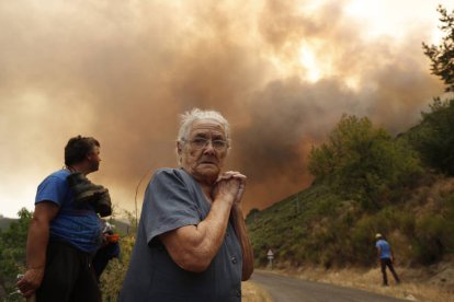 Una vecina se lamenta del fuego a las puertas de su pueblo, en La Cabrera.