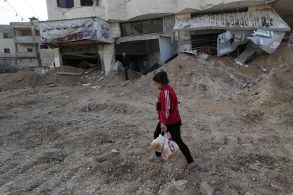 Una joven palestina camina por una zona bomardeada de Yenín este 20 de noviembre. EFE/EPA/ALAA BADARNEH