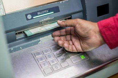 Una persona retira dinero del cajero automático de un banco. EFE/MIGUEL GUTIÉRREZ