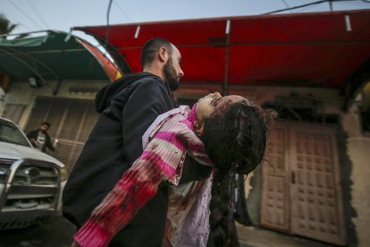 Un palestino traslada el cuerpo de un niña herida a un hospital de Deir Al Balah, en el centro de Gaza. EFE/EPA/MOHAMMED SABER