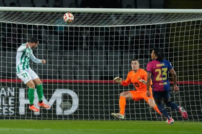 El delantero del Betis Juanmi (i) remata de cabeza durante el partido de los octavos de final de la Copa del Rey en el Estadio Olímpico Lluis Companys. EFE/ Enric Fontcuberta
