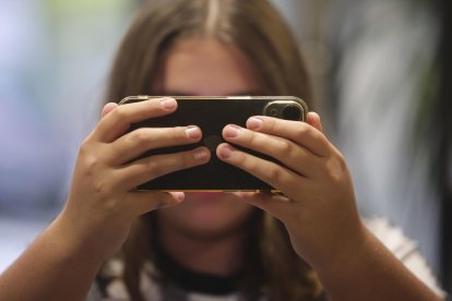 Fotografía de archivo, tomada el 20/10/2023, que muestra a una niña que mira su teléfono móvil en España. EFE/ J.M. García