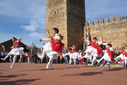 Varios danzantes de Laguna de Negrillos bailan en una exhibición ante el castillo.