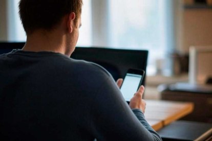 Un joven interactúa con su teléfono móvil