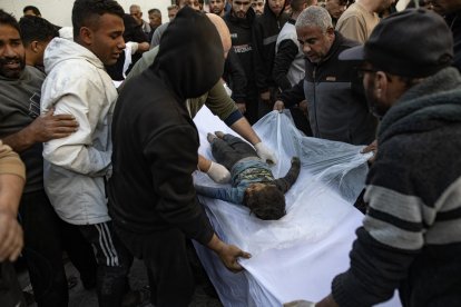 Unos palestinos alrededor del cuerpo de un niño que fue muerto en los ataques aéreos israelíes, en el Hospital Al-Maadani en la Ciudad de Gaza, el 18 de marzo de 2025. EFE/EPA/HAITHAM IMAD