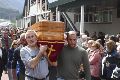 Familiares y amigos portan el féretro de uno de los fallecidos tras la misa funeral el pasado miércoles en el polideportivo municipal de Villablino.